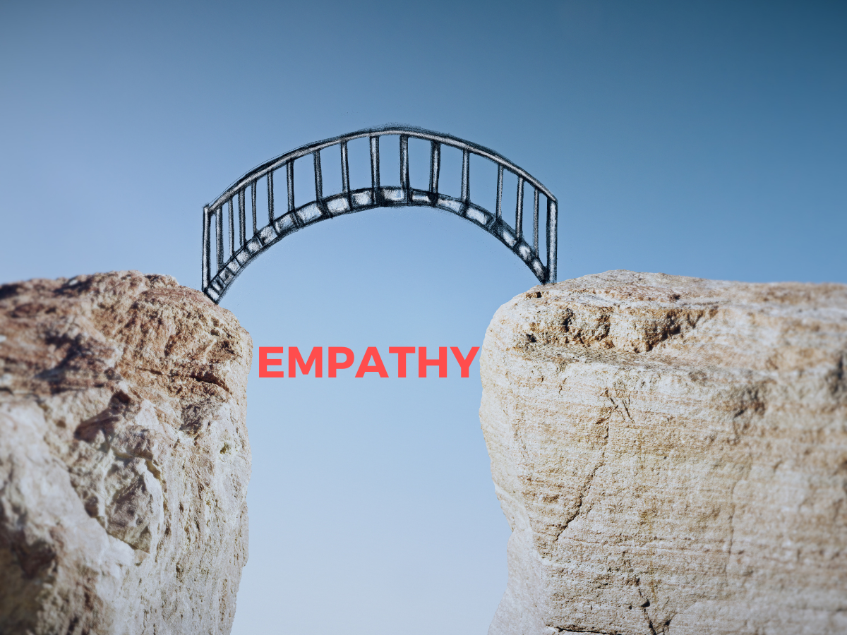 two large boulders with large gap in between with the word "empathy" under a bridge